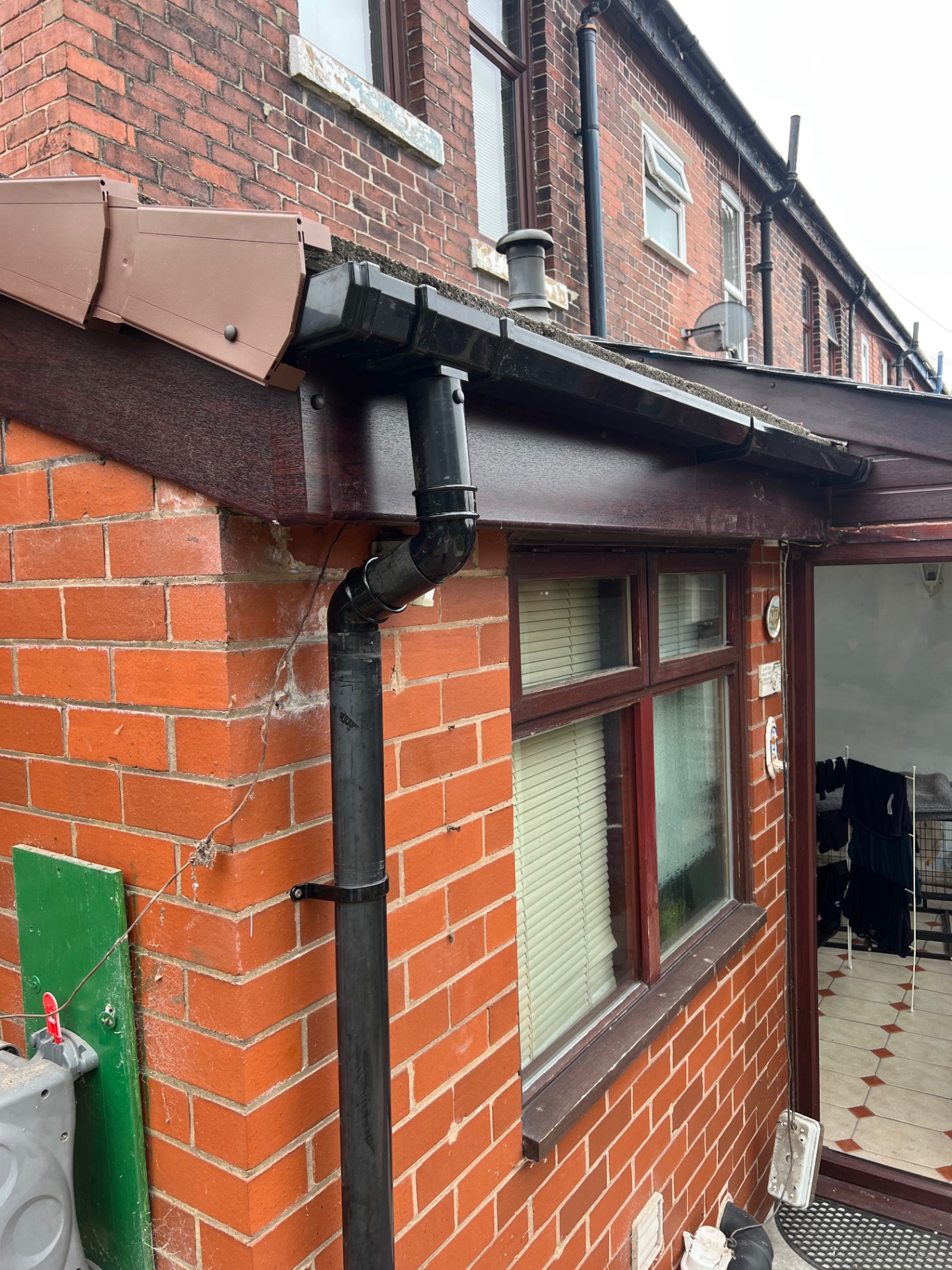New black uPVC guttering, fascias and downpipe on red brick property